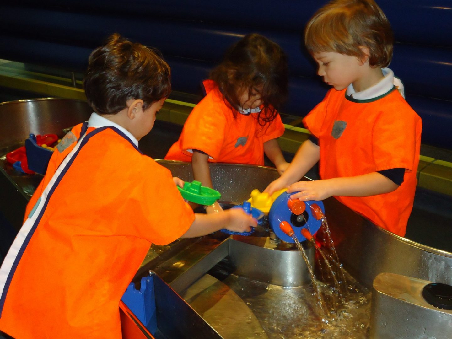 The Nursery children investigating floating and sinking in the water play area